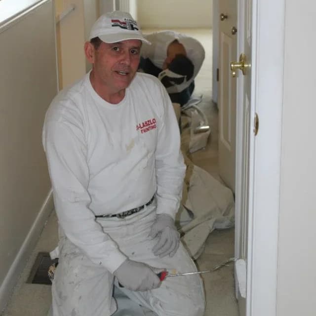 Laszlo Nagy painting trim on a job site